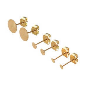 May include: Set of four gold-toned earring posts with round, flat backs in different sizes.
