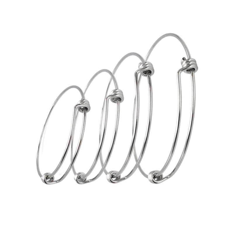May include: Four silver bangle bracelets of different sizes, each with a twisted wire closure.