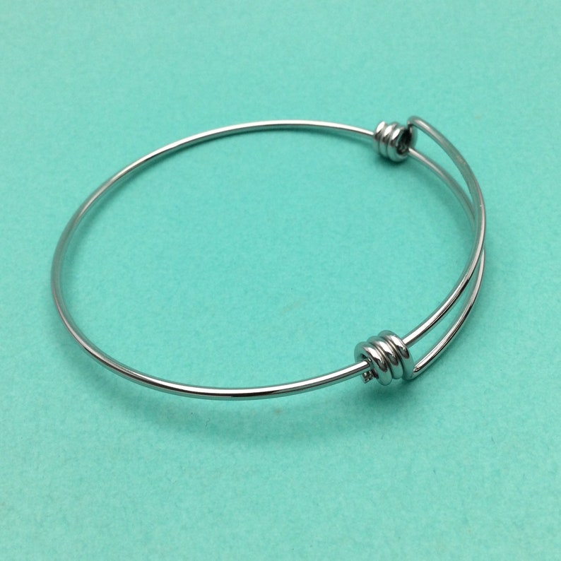 May include: A silver expandable bangle bracelet with a twisted wire design.