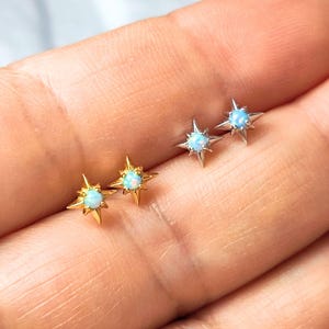 May include: Three pairs of star-shaped earrings with opal stones. The earrings are in gold and silver.