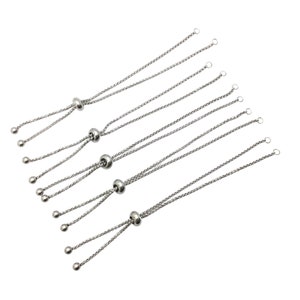 May include: Six silver adjustable bracelet cords with a silver bead at the center of each cord. The cords are made of a fine chain link and have a loop at each end.