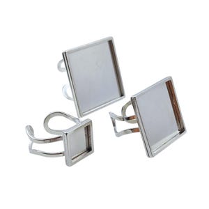 May include: Three silver-toned adjustable rings with square bezels. The rings have a simple, modern design, with a square setting for adding a custom design. The rings are displayed against a white background.