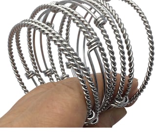May include: Set of six silver-toned bangle bracelets with a twisted rope design. The bracelets are stacked on top of each other.