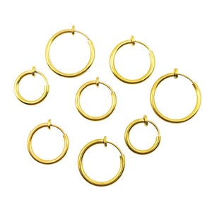 May include: Set of seven gold-toned non-pierced hoop earrings. The hoops are of varying sizes and are designed to clip onto the ear.