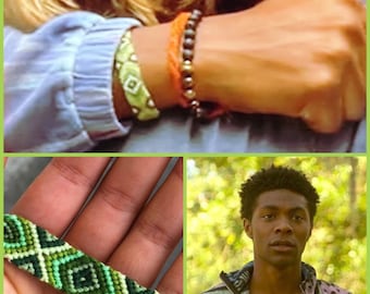 Könnte beinhalten: Ein gewebtes Freundschaftsarmband mit einem geometrischen Rautenmuster in Hellgrün, Dunkelgrün und Weiß. Das Armband ist am Handgelenk neben einem orangefarbenen Kordelarmband und einem dunklen Perlenarmband zu sehen und wird von einer Person getragen.