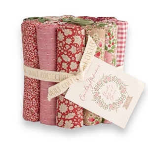 Könnte beinhalten: Ein Bündel gerollter Stoffe in verschiedenen floralen und gemusterten Designs, mit einem Band gebunden. Die Stoffe sind hauptsächlich rot, rosa und cremefarben, mit einem Etikett "Country Memories, Winter Life and Greens."