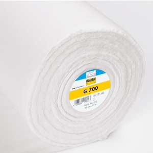 Könnte beinhalten: Eine weiße Rolle Vlieseline G 700 Vlieseline. Das Etikett zeigt den Produktnamen, die Marke und die Größe: 90 cm x 25 m. Das Etikett enthält auch Pflegehinweise und einen Barcode.