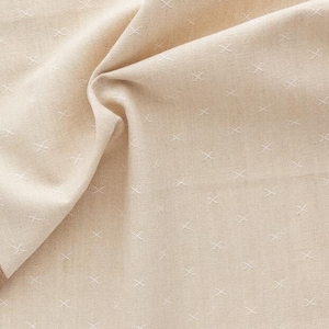 Könnte beinhalten: Beigefarbener Stoff mit einem dezenten Kreuzstichmuster. Der Stoff hat einen braunen Rand und ist drapiert, wodurch seine Textur und Falten sichtbar werden. Das Wort "FABLEISM" ist unten aufgedruckt.