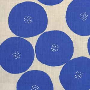Könnte beinhalten: Ein weißer Stoff mit einem sich wiederholenden Muster aus blauen Kreisen. Die Kreise haben ein weißes Punktmuster in der Mitte.