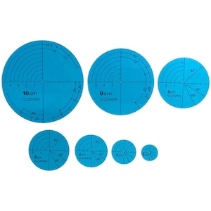 Könnte beinhalten: Ein Set aus sechs blauen, kreisförmigen Quilt-Schablonen mit Durchmessern von 2cm bis 10cm. Jede Schablone hat Gradmarkierungen und Zentimeter-Messungen, mit dem Markennamen "CLOVER" aufgedruckt.