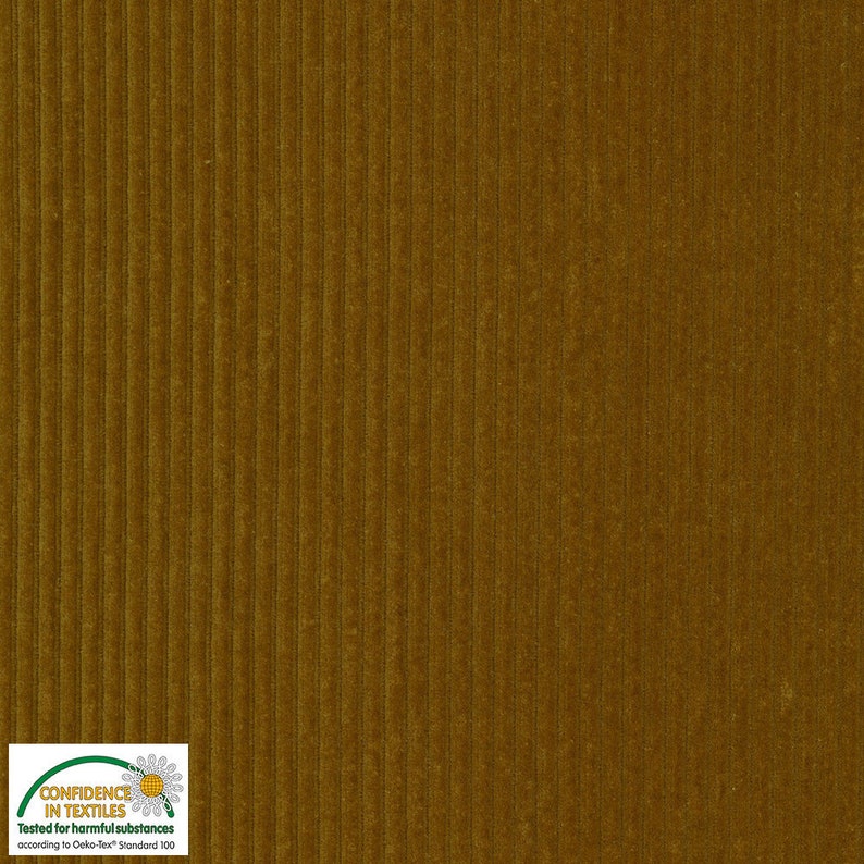 May include: Close-up of a textured, golden-brown corduroy fabric. The fabric has vertical ridges and a soft, velvety appearance. The image showcases the material's color and texture, suitable for apparel or home decor.