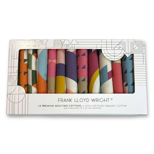Könnte beinhalten: Eine Schachtel mit 12 Premium-Quilting-Baumwollstoffen, jeweils 45.7 cm x 55.9 cm groß, mit farbenfrohen geometrischen Mustern. Die Schachtel trägt den Text "FRANK LLOYD WRIGHT®" und "100% CERTIFIED ORGANIC COTTON".