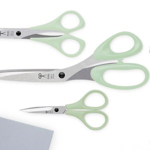 Könnte beinhalten: Drei Scheren mit mintgrünen Griffen und silbernen Klingen. Die Scheren sind in verschiedenen Größen. Die größte Schere trägt den Text "PAUL Made in Germany" auf der Klinge.