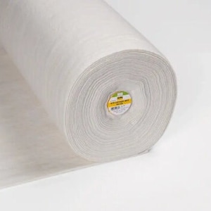 Könnte beinhalten: Eine weiße Rolle aus nicht gewebtem Einlagevlies. Der Stoff wird verwendet, um Stoffe in Näh- und Quiltprojekten zu stabilisieren und zu verstärken.