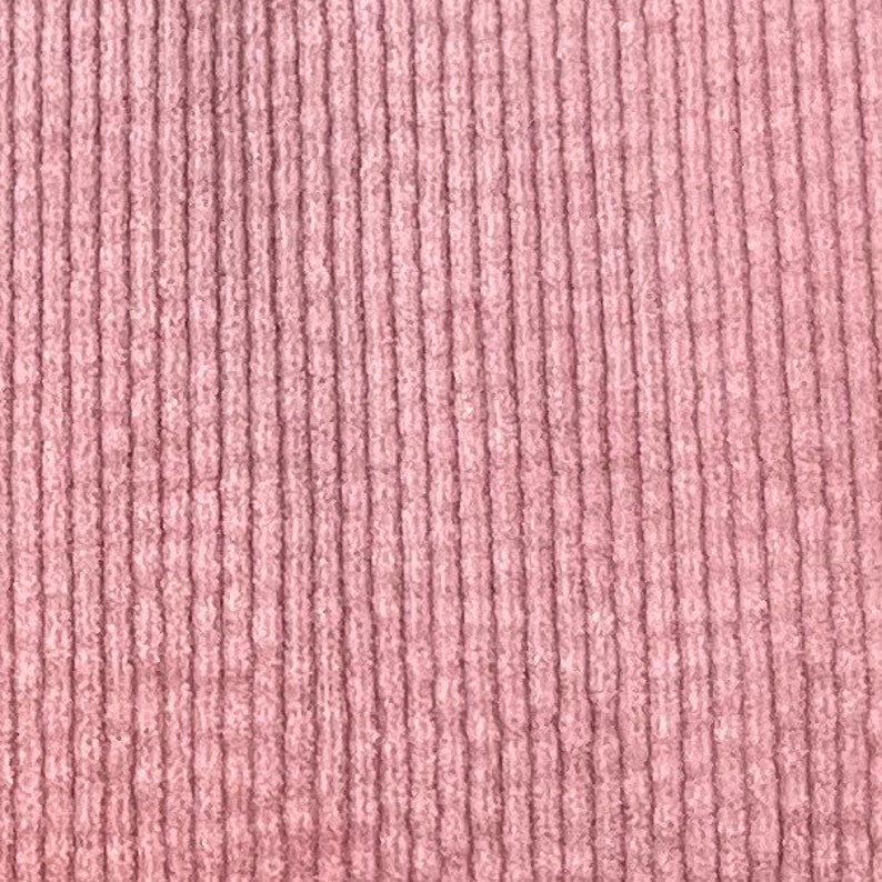 Puede incluir: Primer plano de una tela de pana rosa con una textura acanalada vertical.