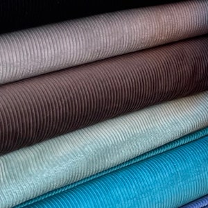 K&ouml;nnte beinhalten: Ein Stapel aus sechs verschiedenen Cordstoffen. Die Stoffe sind von dunkel nach hell angeordnet, mit Schwarz unten und Hellblau oben.