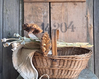 May include: A rustic wicker basket with a wooden handle, filled with dried sunflowers, wheat, and poppy seed heads. The basket sits on a weathered wooden surface, with a wooden backdrop featuring the number "14904".