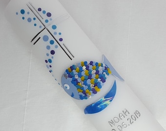May include: White baptism candle with a blue and yellow fish design and the name Noah and date 29.06.2019.