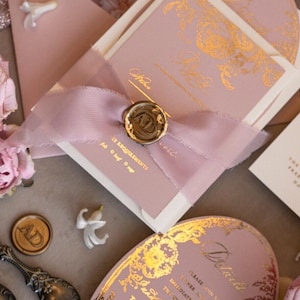 May include: Pink and white wedding invitation with gold foil accents. The invitation features a floral design and the text "The Garden Valley Pond" and "The Garden, the right".