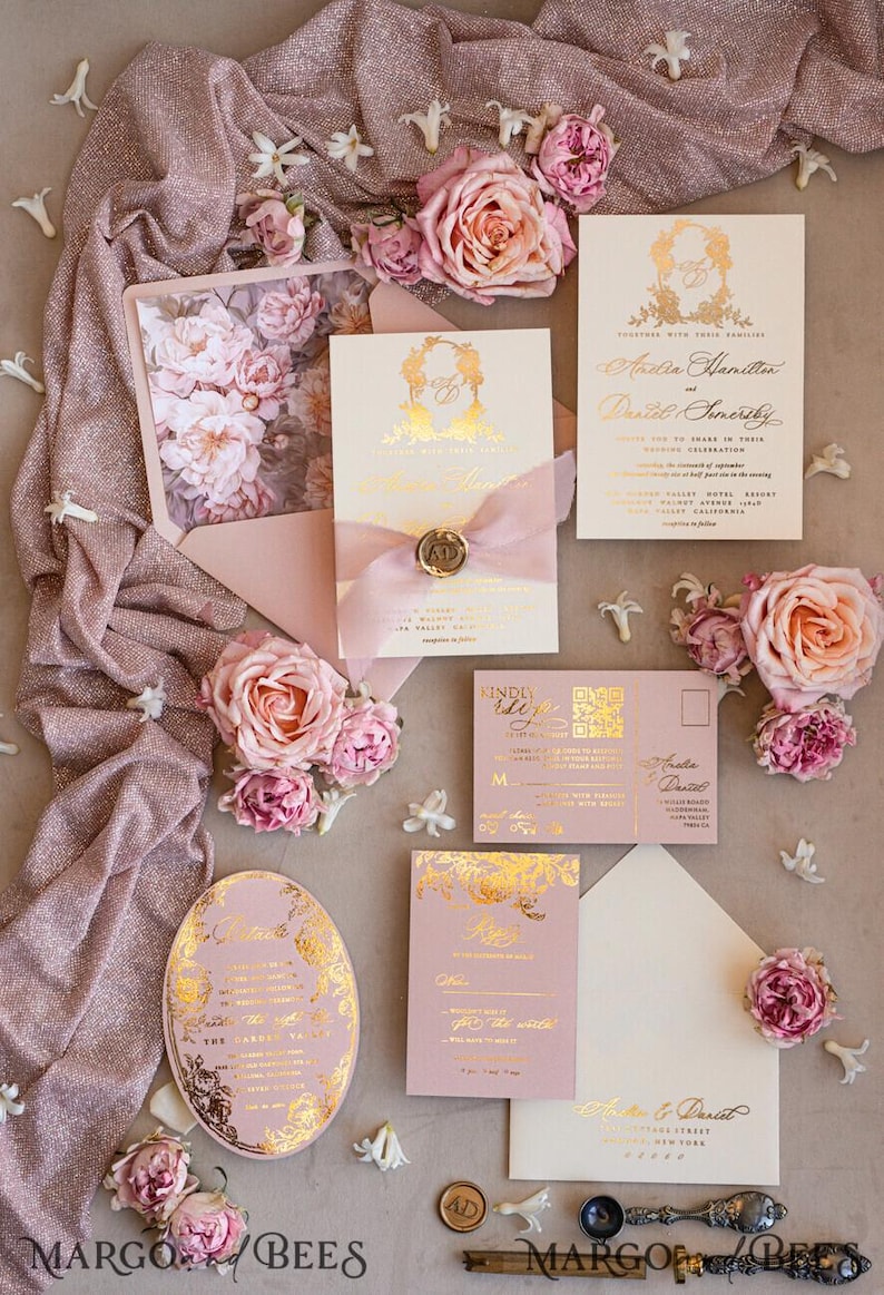 May include: Pink and white wedding invitation suite with gold foil accents. The invitation features a floral design with the couple's names and wedding date. The RSVP card is pink with gold foil accents. The envelope is white with a gold foil address.