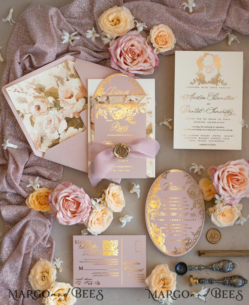 May include: A blush pink wedding invitation suite with gold foil accents and floral designs. The invitation features the couple's names, wedding date, and location. The RSVP card includes a QR code. The invitation is decorated with blush pink roses and a pink ribbon.