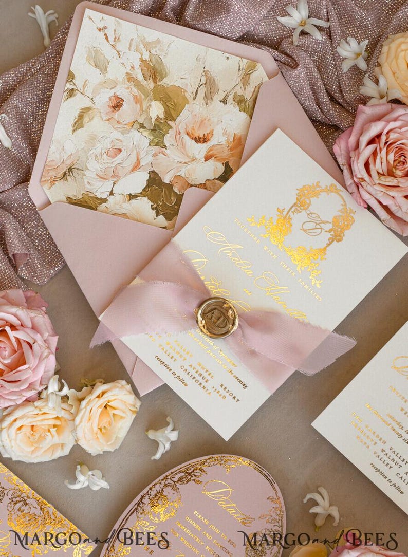 May include: A wedding invitation suite with a pink envelope, a white card with gold foil lettering, and a pink ribbon with a wax seal. The invitation features a floral design with a gold monogram.