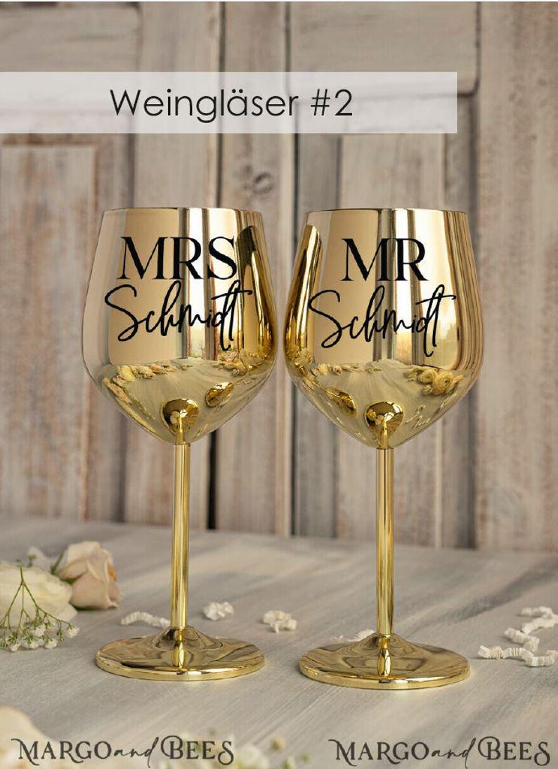 May include: Two gold-colored wine glasses with black lettering. The glass on the left says "MRS Schmidt" and the glass on the right says "MR Schmidt".
