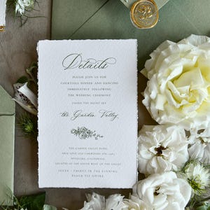 May include: A rectangular white wedding details card with deckled edges and black serif and script text. The card reads Details, Please join us for cocktails dinner and dancing, The Garden Valley, and location information, accented by a floral illustration.