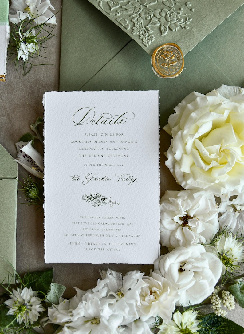 May include: A rectangular white wedding details card with deckled edges and black serif and script text. The card reads Details, Please join us for cocktails dinner and dancing, The Garden Valley, and location information, accented by a floral illustration.