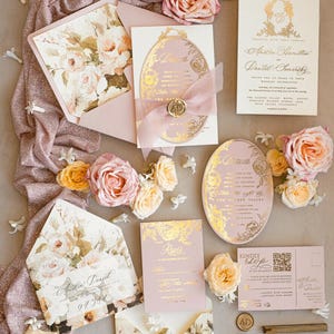 May include: Pink and gold wedding invitation suite with floral details. The invitations feature a delicate floral pattern and gold foil accents. The RSVP card has a gold foil border and the text "RSVP" in gold lettering. The invitation is set on a pink and gold fabric background with pink and yellow flowers.