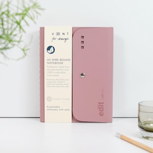 May include: A pink A5 wire-bound notebook made from recycled leather and 100% sustainable lined paper. The notebook cover has the text "VNT for change" and "edit [edit]" printed on it. The notebook is part of a sustainable stationery line.