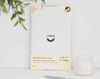 May include: A white notebook with the word "LINES" and a curved line printed on the front. The notebook is a double refill pack for a week planner and lined paper. It is made from 100% sustainable paper. The text "VNT for change" is printed on the bottom right corner of the notebook.