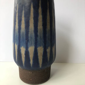Könnte beinhalten: Eine blaue und weiße Keramikvase mit geometrischem Muster. Die Vase hat einen breiten Boden und einen schmalen Hals.