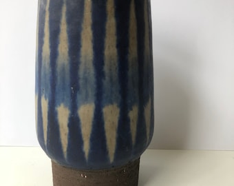Może przedstawiać: Niebieski i biały ceramiczny wazon z geometrycznym wzorem. Wazon ma szeroką podstawę i wąską szyjkę.