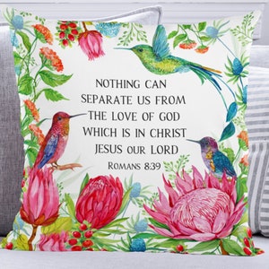 May include: White cushion with a floral design featuring pink proteas, green leaves, and hummingbirds. The cushion has a quote from Romans 8:39 that reads "Nothing can separate us from the love of God which is in Christ Jesus our Lord."