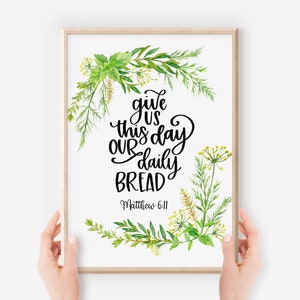 Puede incluir: Un diseño de arte de pared imprimible con una ilustración de acuarela de hierbas verdes y flores amarillas que rodean el texto "danos hoy nuestro pan de cada día" con la referencia bíblica "Mateo 6:11".