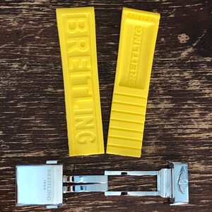 May include: Two yellow rubber watch straps with the word "BREITLING" embossed on them. The straps are 1523 22-20. A silver watch band with the word "BREITLING 1884" engraved on it.