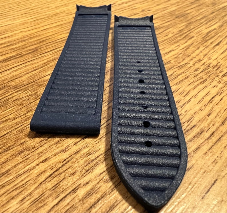 Puede incluir: Dos correas de reloj azul oscuro con una superficie texturizada. Las correas est&aacute;n hechas de un material similar al caucho.