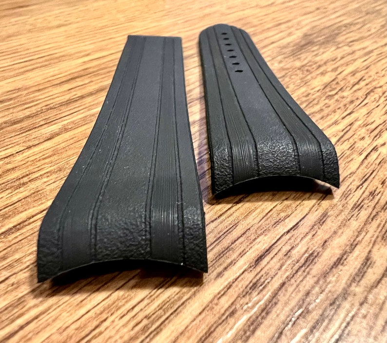 Puede incluir: Dos correas de reloj de goma negra con una superficie texturizada y un dise&ntilde;o acanalado.