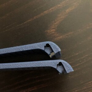 Puede incluir: Dos correas de reloj de pl&aacute;stico azul con agujeros para sujetarlas a un reloj.