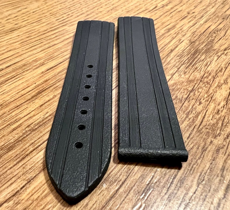 Puede incluir: Dos correas de reloj de goma negra con una superficie texturizada y m&uacute;ltiples agujeros para ajustar el tama&ntilde;o.