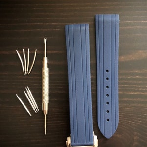 Puede incluir: Dos correas de reloj de silicona azul con una herramienta de correa de reloj plateada y pasadores de resorte.