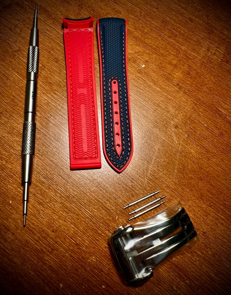 Puede incluir: Kit de reemplazo de correa de reloj con una correa roja y azul marino, una herramienta plateada, pasadores plateados y un cierre plateado. La correa roja tiene un dise&ntilde;o texturizado. La correa azul marino tiene costuras rojas.