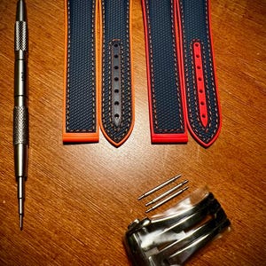 Puede incluir: Un juego de correas de reloj con una herramienta de acero inoxidable, dos correas azules y naranjas y dos correas rojas y azules. Tambi&eacute;n se incluyen barras de resorte y un cierre de acero inoxidable. Las correas tienen una superficie texturizada y costuras en contraste.