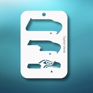 May include: White stencil featuring three different designs of a bird's head, with a small hole at the top for hanging. The text "Daydream Stencils" is printed vertically on the right side. The background is a gradient of blue.