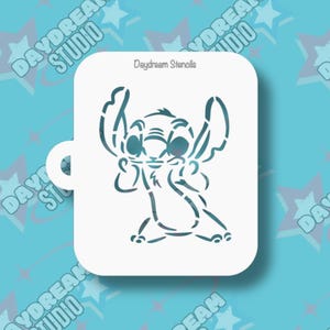 May include: A white stencil featuring a teal outline of the character Stitch from the Disney movie Lilo & Stitch. The stencil is rectangular with rounded corners and the text "Daydream Stencils" is printed at the top.