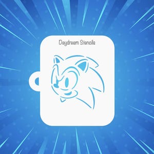 May include: A white rectangular stencil featuring a cutout of a cartoon hedgehog head and the text Daydream Stencils printed at the top. The stencil has a small circular tab on the left side for hanging or handling during use in various projects.