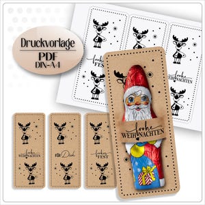 May include: A collection of Christmas-themed gift tags and labels. The tags feature a reindeer design and the words "Frohe Weihnachten" and "Für Dich". A Santa Claus chocolate bar is also visible.