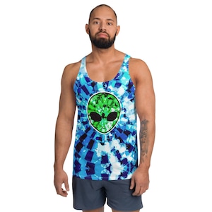 Puede incluir: Un tanque de color azul y verde tie-dye con un gráfico de cara de extraterrestre verde. El tanque tiene un cuello redondo y un ajuste relajado.