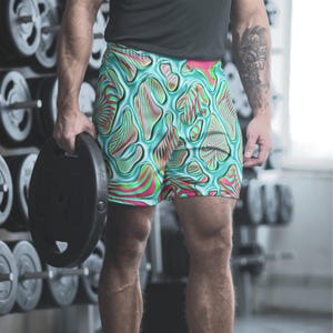 May include: Form-fitting athletic shorts with a striking abstract design in teal, pink, and green. The shorts have a bold, colourful pattern. Ideal for gym workouts or everyday wear. The shorts are approximately 30 cm in length.